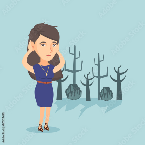 Young caucasian disappointed woman scratching head while standing in a dead forest caused by global warming or wildfire