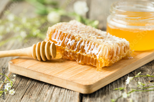 Honeycomb on wooden board with honey spoon