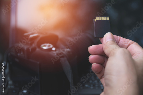 Bild auf Leinwand Photographer's hand holding memory card for preparing his camera before photography
