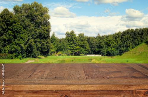 wooden table in front green forest trees landscape background. for product display and presentation