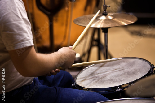  Hands of a man playing a drum set