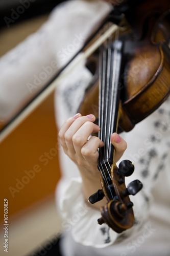 Hand girl playing the violin closeup