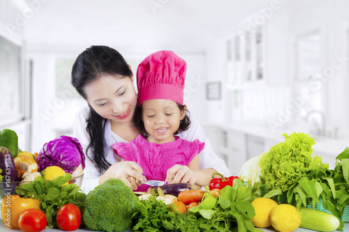 Asian mother and daughter prepare vegetables