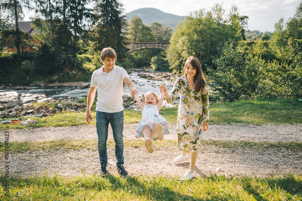 Fototapeta premium young family plaing with her daughter in mountains