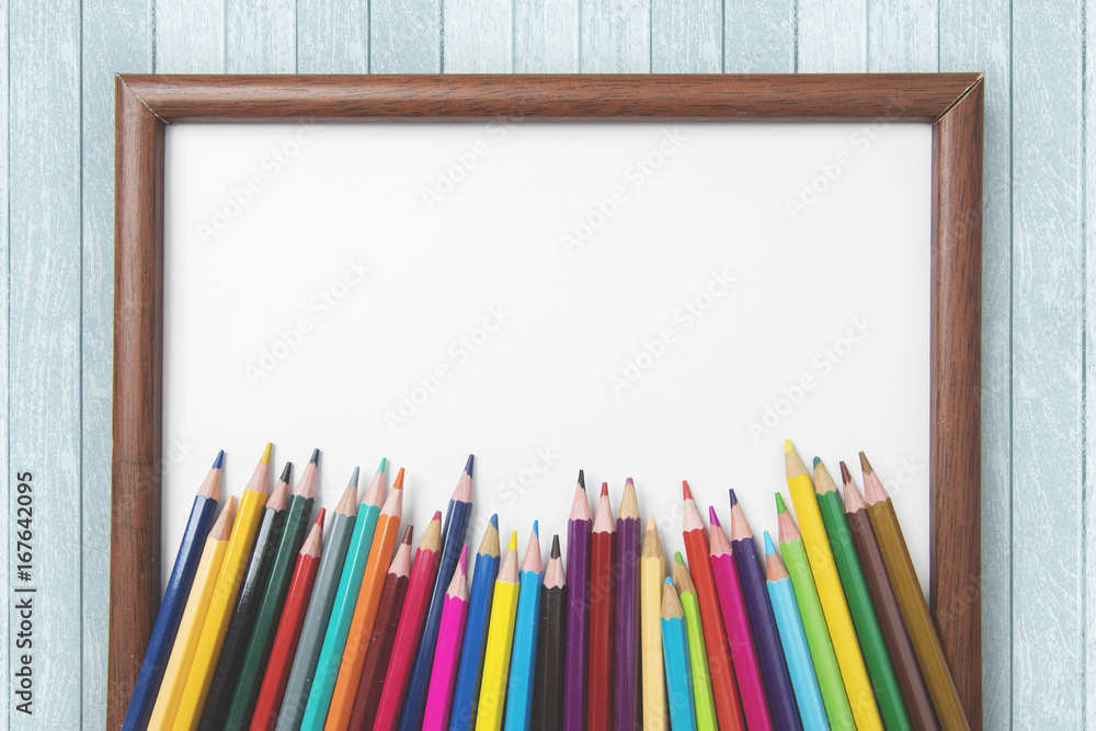 Colored pencils with blank frame on the table Colored pencils with blank frame on the table