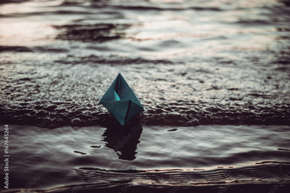 Blue lonely paper boat