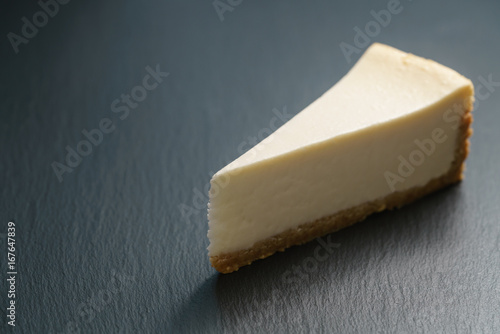 slice of new york cheesecake on slate board