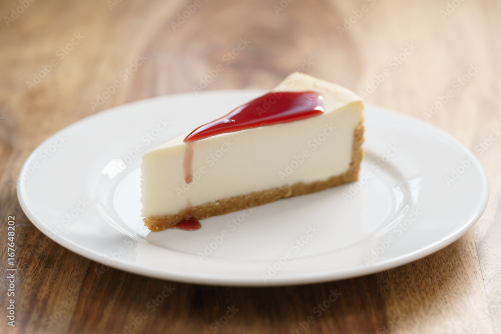 raditional new york cheesecake with berry jam on white plate on wood table raditional new york cheesecake with berry jam on white plate on wood table