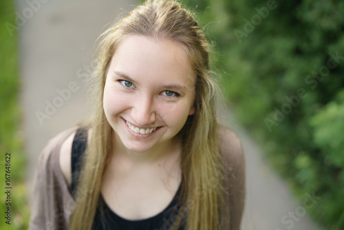 teen girl smiling in town in sunny summer day from above