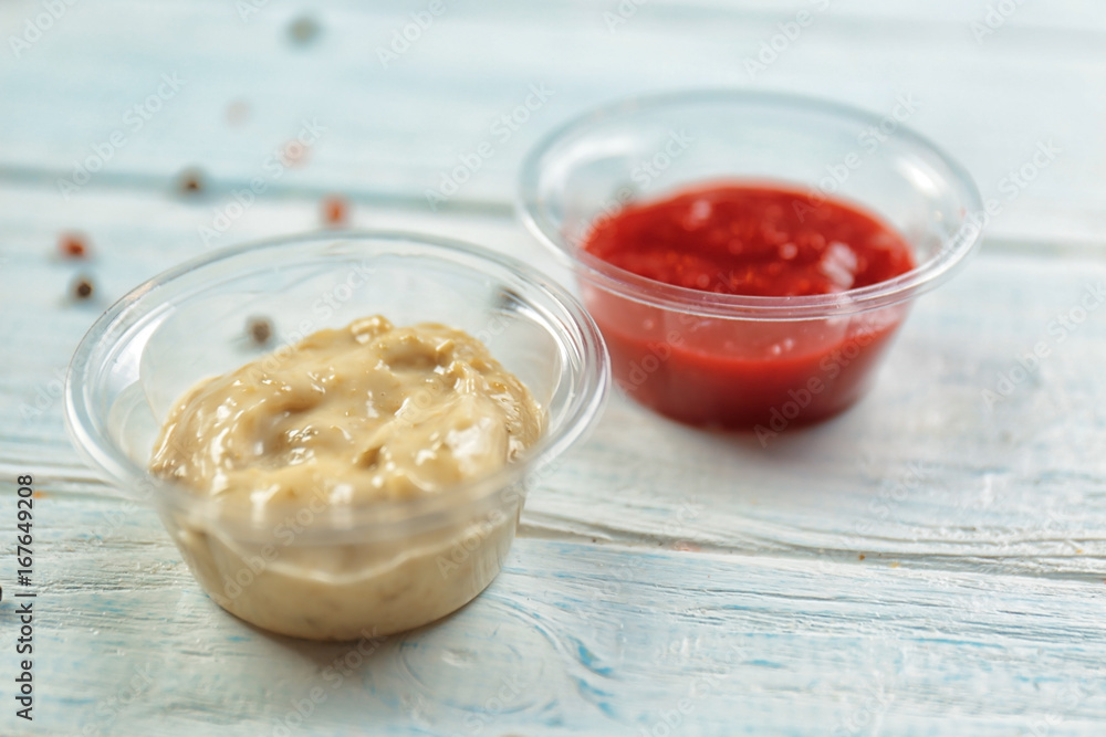 Tasty sauces in plastic bowls on table Tasty sauces in plastic bowls on table