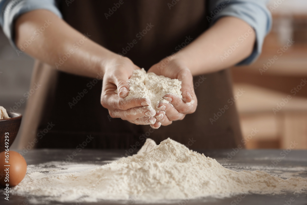 Female chef holding white flour in hands at kitchen Female chef holding white flour in hands at kitchen