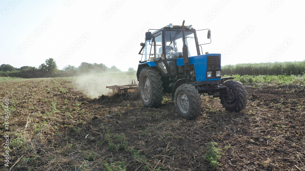 Agricultural tractor sowing and cultivating field at organic eco farm Agricultural tractor sowing and cultivating field at organic eco farm