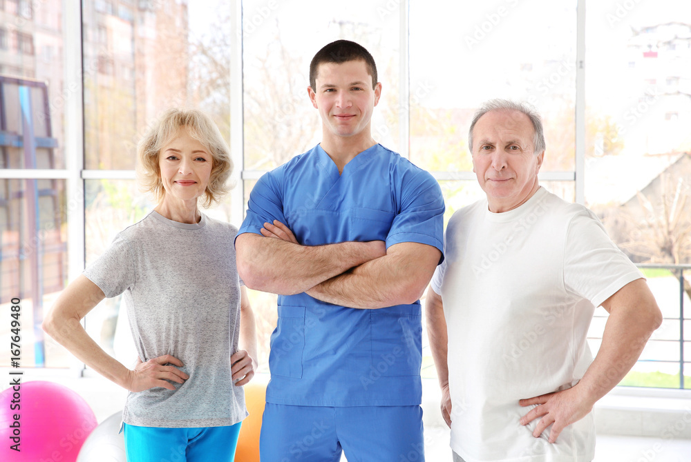 Fototapeta premium Physiotherapist with elderly patients in modern clinic