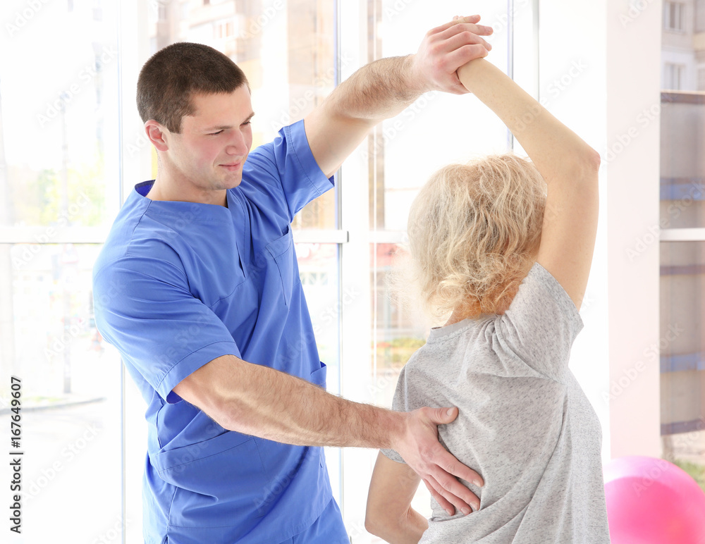 Obraz premium Physiotherapist working with elderly patient in clinic
