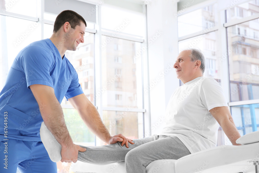 Physiotherapist working with elderly patient in clinic Physiotherapist working with elderly patient in clinic