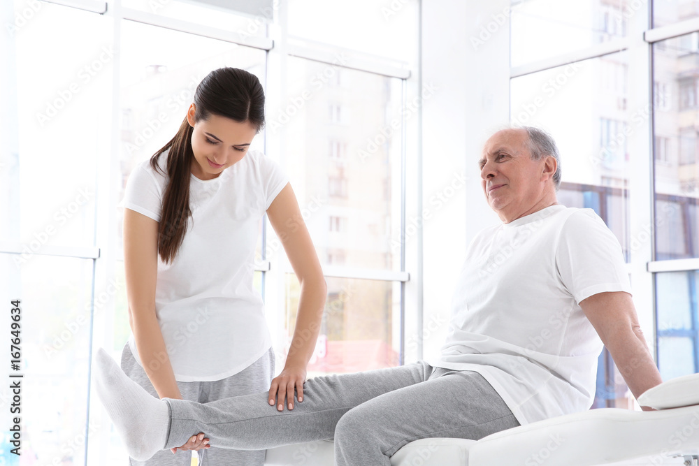 Physiotherapist working with elderly patient in clinic Physiotherapist working with elderly patient in clinic