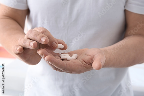 Senior man with pills in hands  closeup