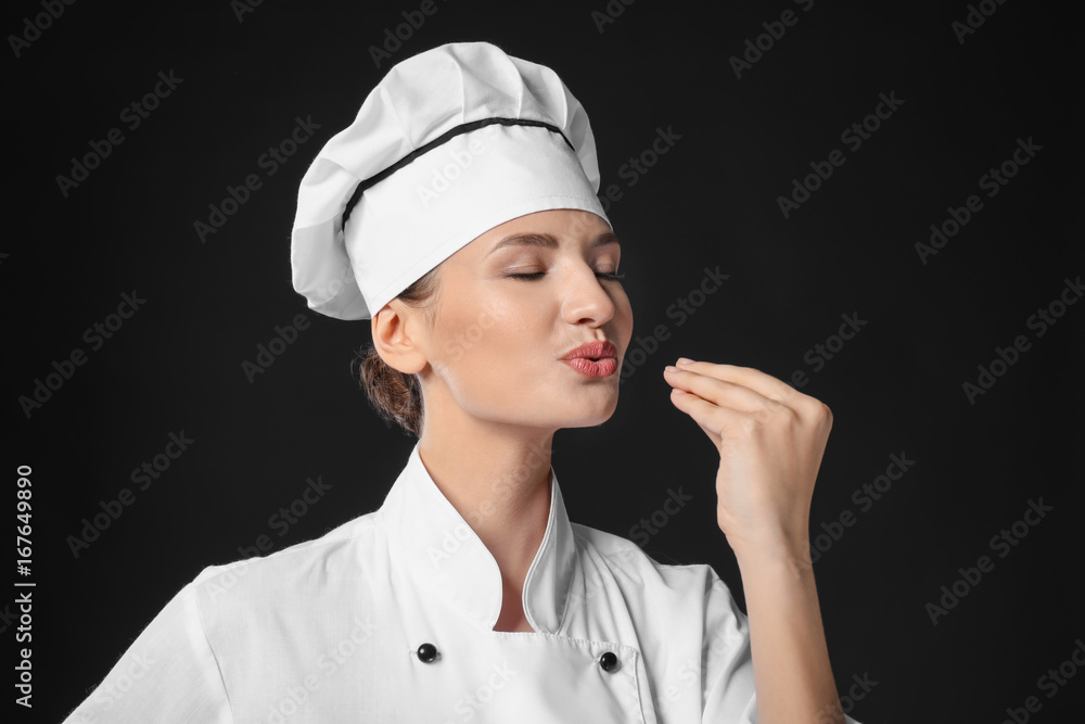 Young female chef on dark background Young female chef on dark background