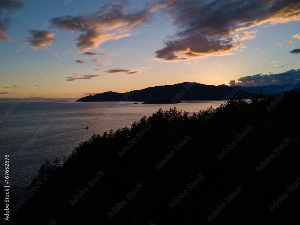 Atmospheric lighthouse on cliff near ocean while sunset Atmospheric lighthouse on cliff near ocean while sunset
