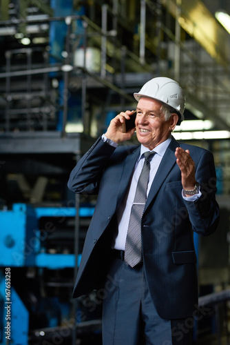 Senior Businessman Speaking by Phone in Factory Workshop
