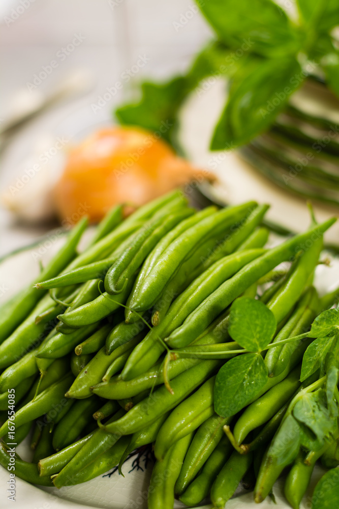 Fresh green snap beans on the plate ready to cook Fresh green snap beans on the plate ready to cook