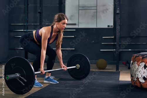 Woman Lifting Heavy Barbell in CrossFit Gym