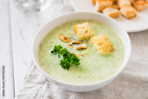 Green healthy cream soup with broccoli, crackers, cashew, parsley