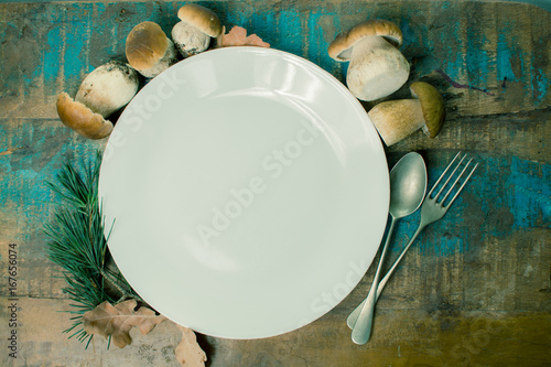 Autumn dinner concept - white dinner plate with fresh porcini boletus oak mushrooms, high quality, ready to cook photo