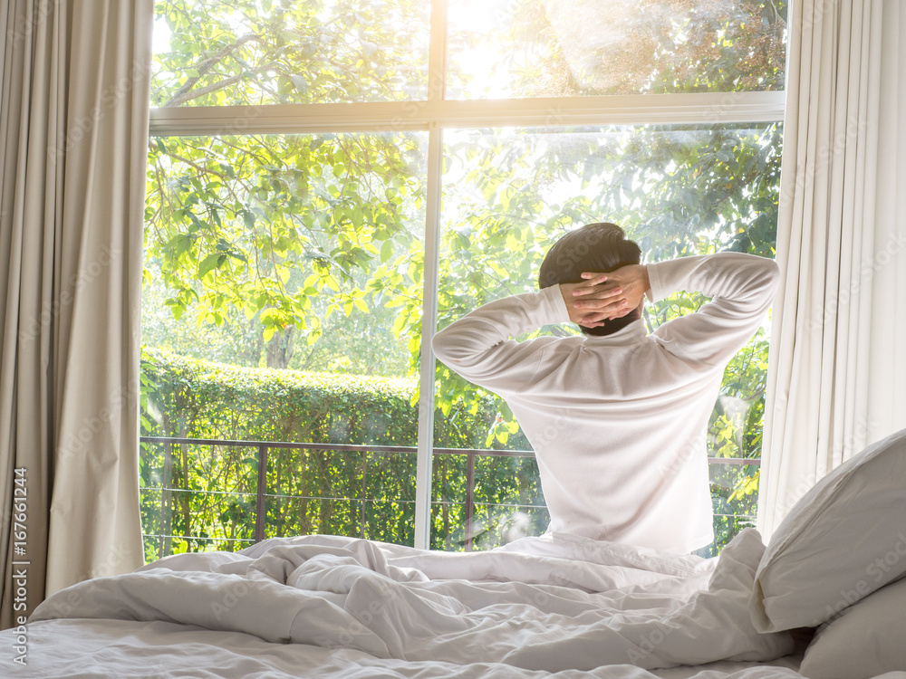 lazy man happy waking up in the bed rising hands to window in the morning with fresh feeling relax lazy man happy waking up in the bed rising hands to window in the morning with fresh feeling relax