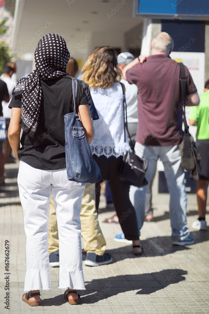 Fototapeta premium people queue in line and woman with headscarf hiyab , selective focus