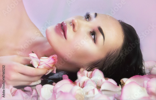 Woman with Fresh Rose petals and pink rosebud. Natural Rose water