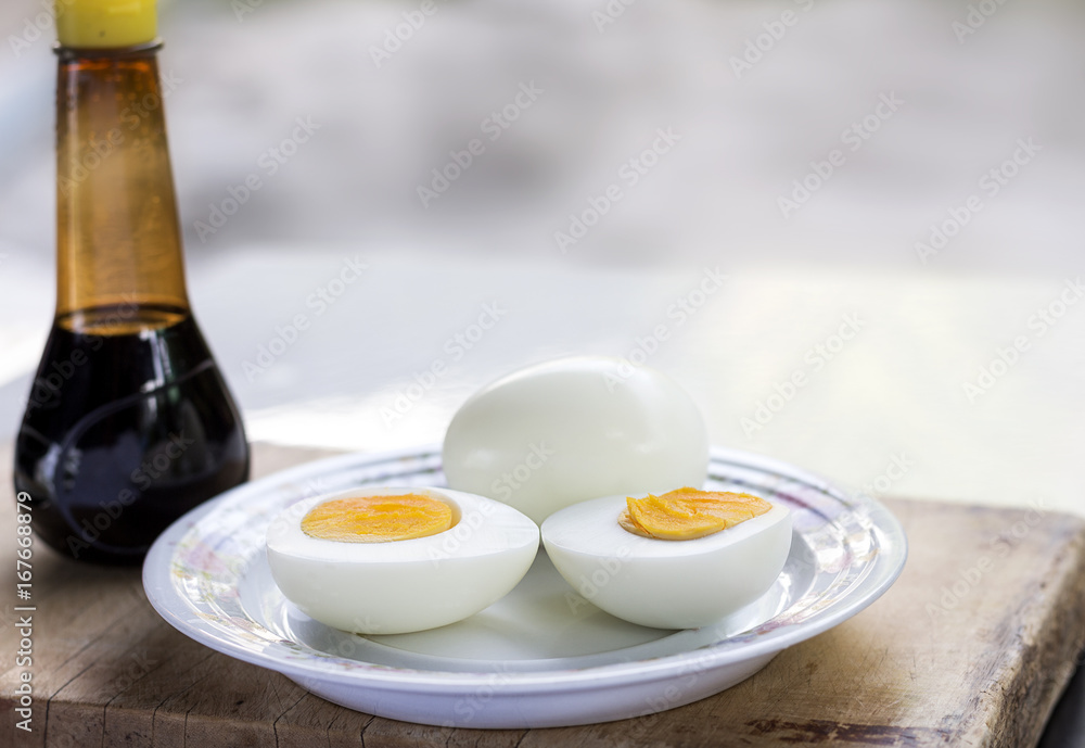 Boiled eggs in a dish placed on the chopping board.