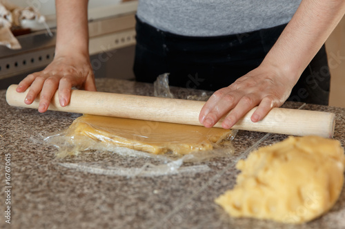 Baker kneading dough in flour on table