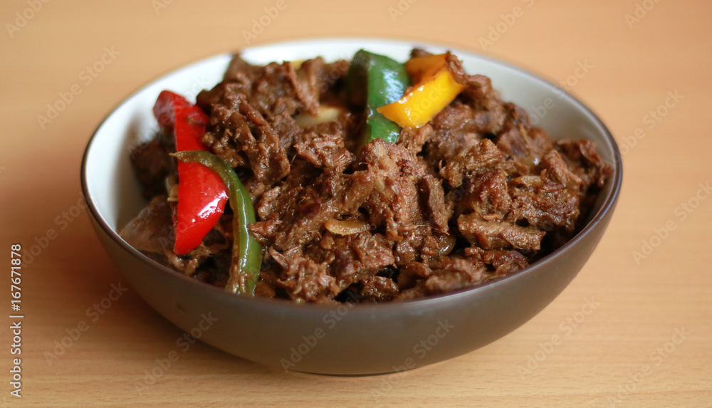 Black pepper beef in bowl with wood background. Black pepper beef in bowl with wood background.