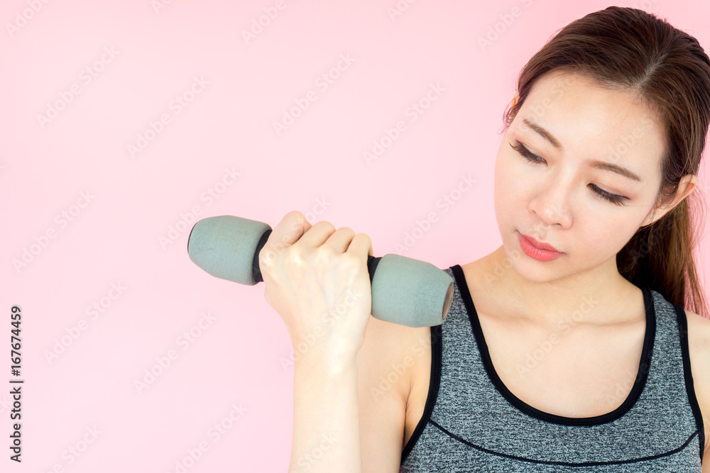 Young asian beautiful woman with sport fitness concept, workout, exercise, holding dumbbell on pink background Young asian beautiful woman with sport fitness concept, workout, exercise, holding dumbbell on pink background