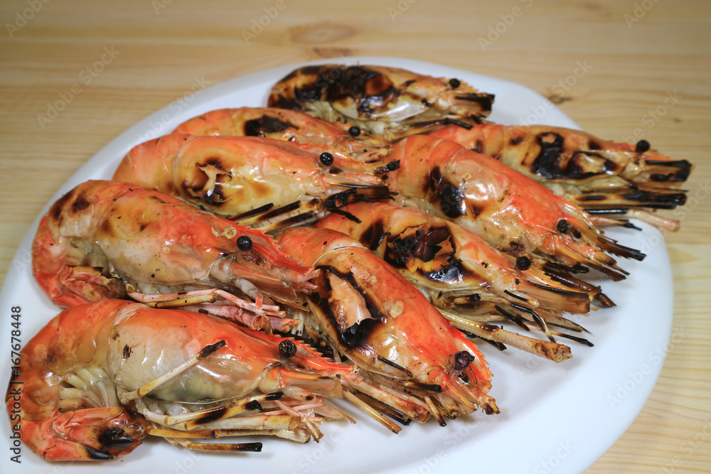 Flaming Grilled Whole River Prawns on White Plate Served on Wooden Table, with Selective Focus Flaming Grilled Whole River Prawns on White Plate Served on Wooden Table, with Selective Focus
