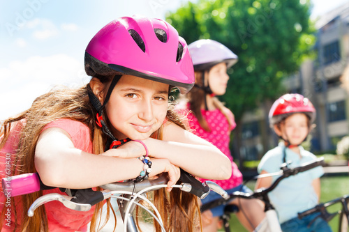 Girl having rest during bicycle ride with friends
