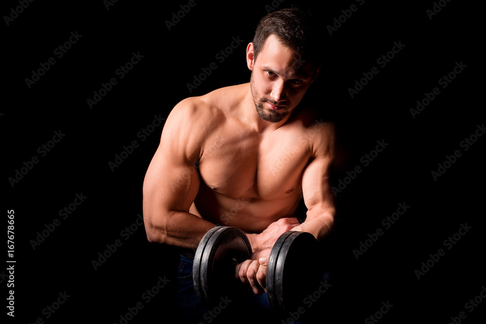 Fitness concept. Muscular and sexy torso of young man having perfect abs, bicep and chest. Male hunk with athletic body holding dumbbell.