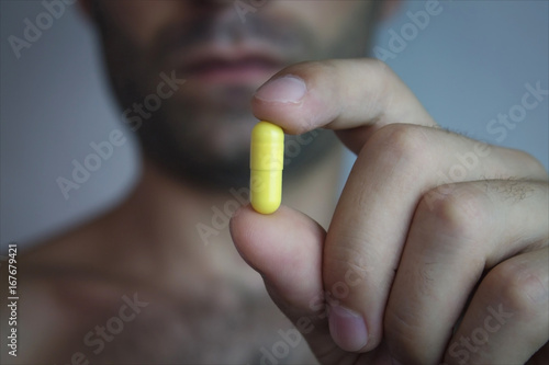 Man holding a pill.