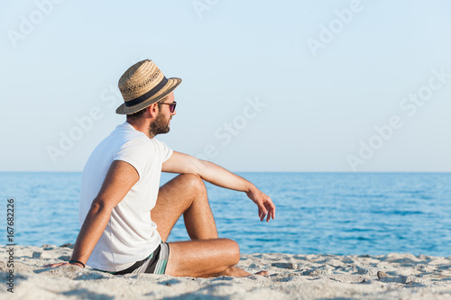 Young hipster man lying on the beach