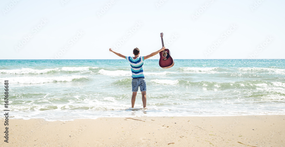 young man with acoustic guitar on the beach young man with acoustic guitar on the beach