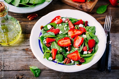 Spinach salad with strawberries, feta cheese, balsamic and pecan nuts