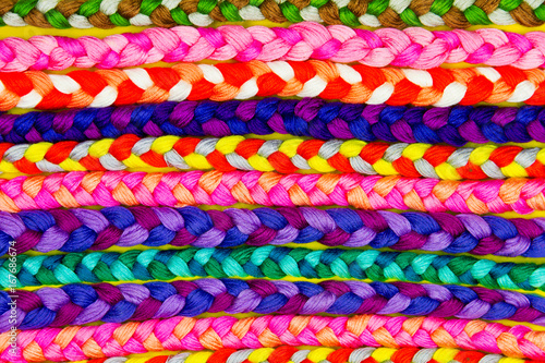 Background   pattern of colorful knitted pigtails from threads. Embroidery concept