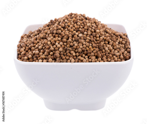 coriander seeds in bowl on white background