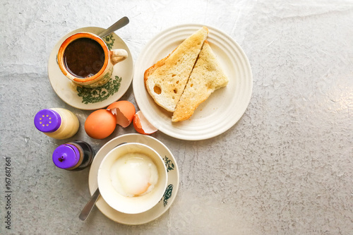 Asian traditional breakfast half boiled eggs, toast bread and coffee