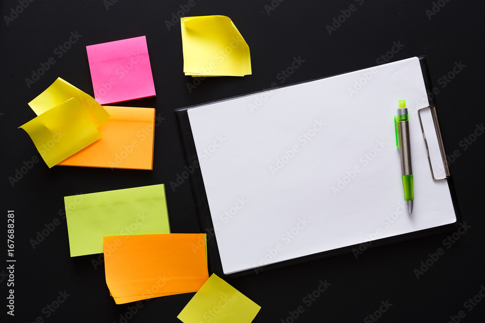 Color notes and note paper on black board, copy space Color notes and note paper on black board, copy space