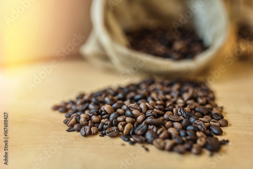Coffee beans in canvas sack on wooden table