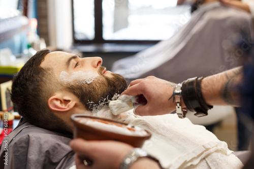 Man getting haircut by hairstylist at barbershop