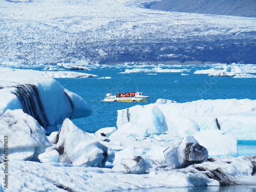 Tableau sur toile Lagune glaciaire de Jökulsarlon : traversée maritime au milieu du bleu intense (