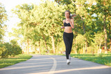 Gorgeous young blonde haired woman running in the forest during her morning fitness routine copyspace nature happiness strength endurance motivation healthy lifestyle concept.